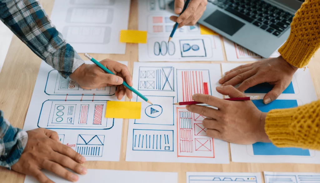 Équipe en train de concevoir un site web à partir de wireframes, puis de l’adapter aux formats mobile et ordinateur